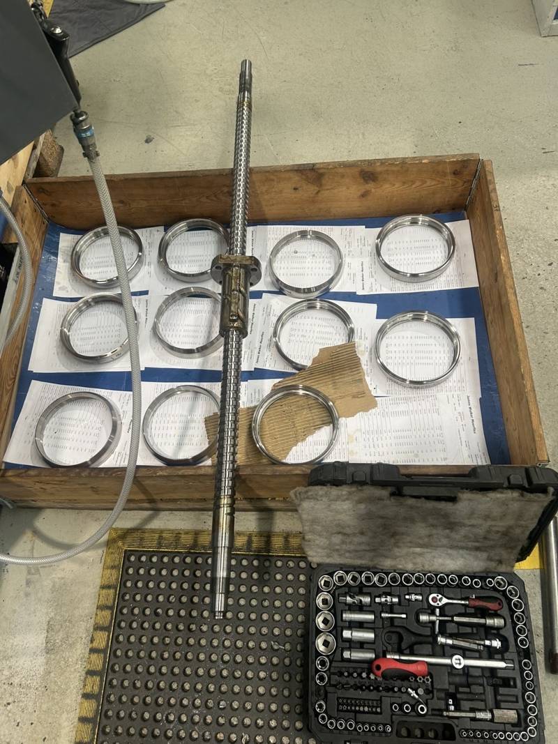 Ballscrew laid across a tray of bearing rings